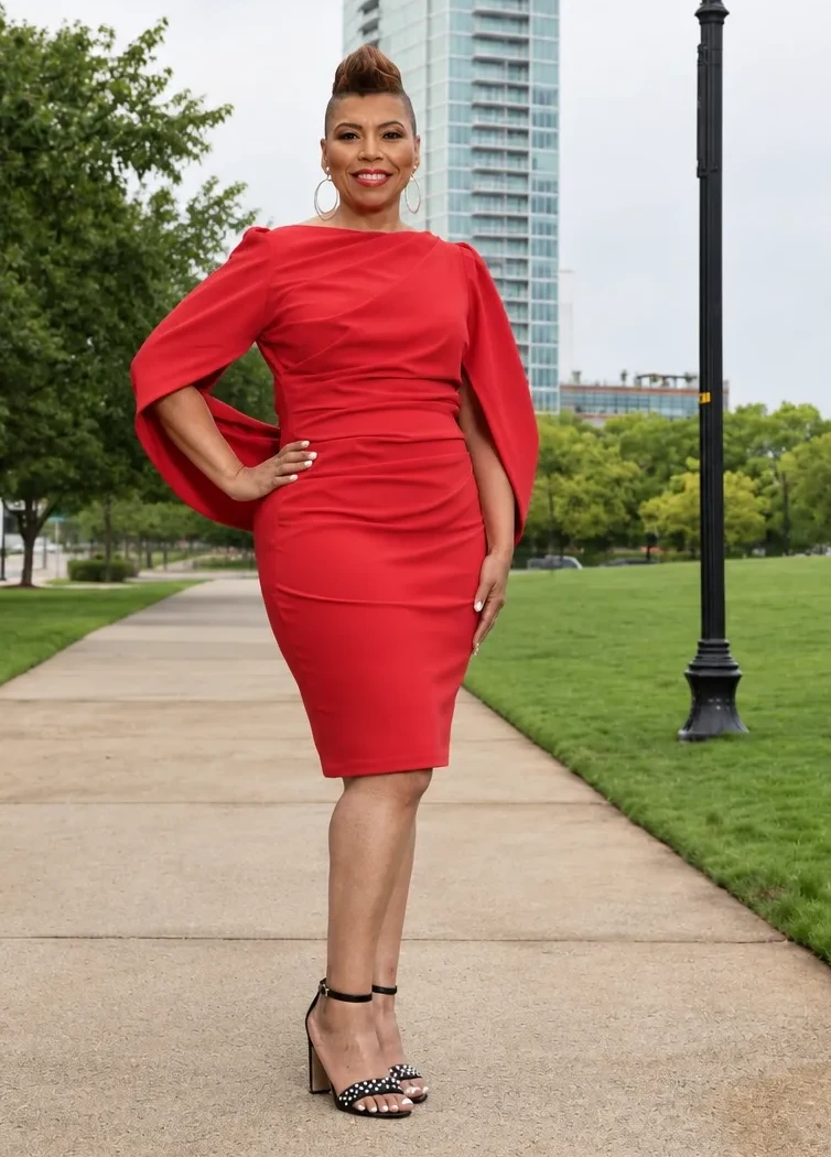 Pastor Elect Elder Tara B. Johnson standing in a red dress on an outdoor walkway